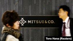 Orang-orang berjalan melewati logo perusahaan perdagangan Jepang Mitsui & Co di Tokyo, Jepang, 10 Januari 2018. (Foto: REUTERS/Toru Hana)