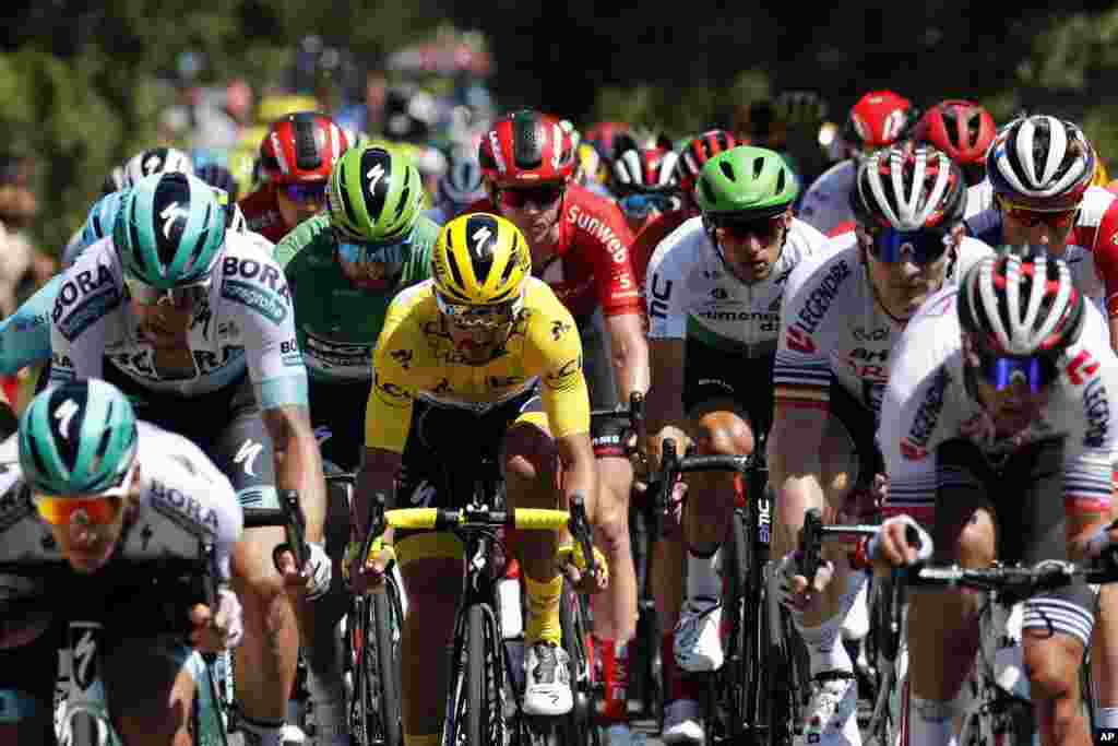 The pack rides with France&#39;s Julian Alaphilippe wearing the overall leader&#39;s yellow jersey during the tenth stage of the Tour de France cycling race over 217 kilometers (135 miles) with start in Saint-Flour and finish in Albi, France.