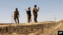 FILE - Iraqi soldiers patrol along the border between Syria and Iraq in Anbar province, Iraq. 