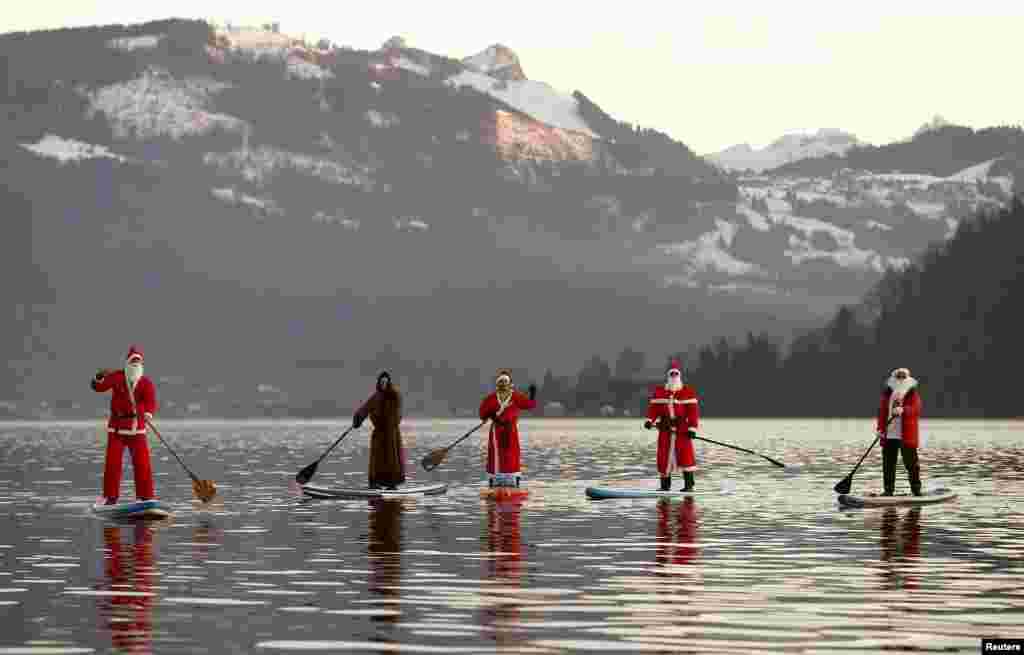 People dressed as Santa Claus cross Lake Aegerisee near Oberaegeri, Switzerland, Dec. 5, 2015. 