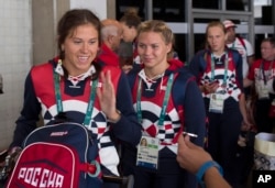 Members of the Russian Olympic delegation line up to board a bus after arriving at the Rio de Janeiro International Airport July 29, 2016, to compete at the 2016 Summer Olympics in Rio de Janeiro, Brazil.