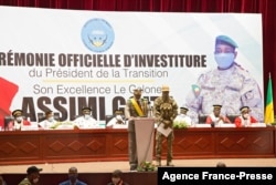 FILE - New interim Malian President, Colonel Assimi Goita (C-L), addresses the nation during his swearing in ceremony in Bamako, June 7, 2021.