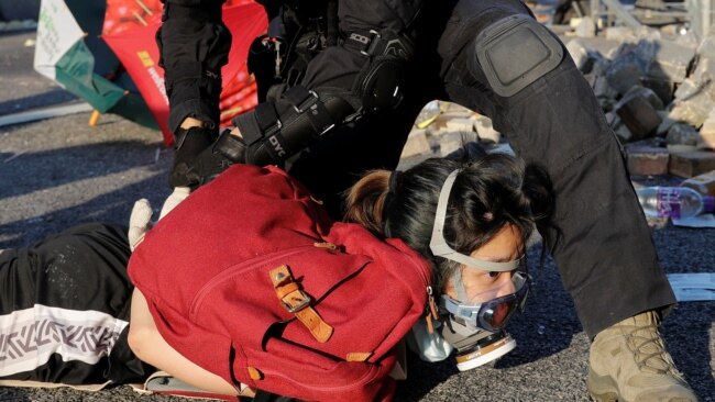 一名香港防暴警察在十一国庆期间的反送中抗议活动中逮捕一名抗议者。（2019年10月1日）