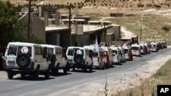 Photo released by the government-controlled Syrian Central Military Media shows ambulances of the Syrian Arab Red Crescent gathering in the Syrian border village of Fleeta, ahead of the evacuations of some Syrian refugees from Lebanon, July 31, 2017. T