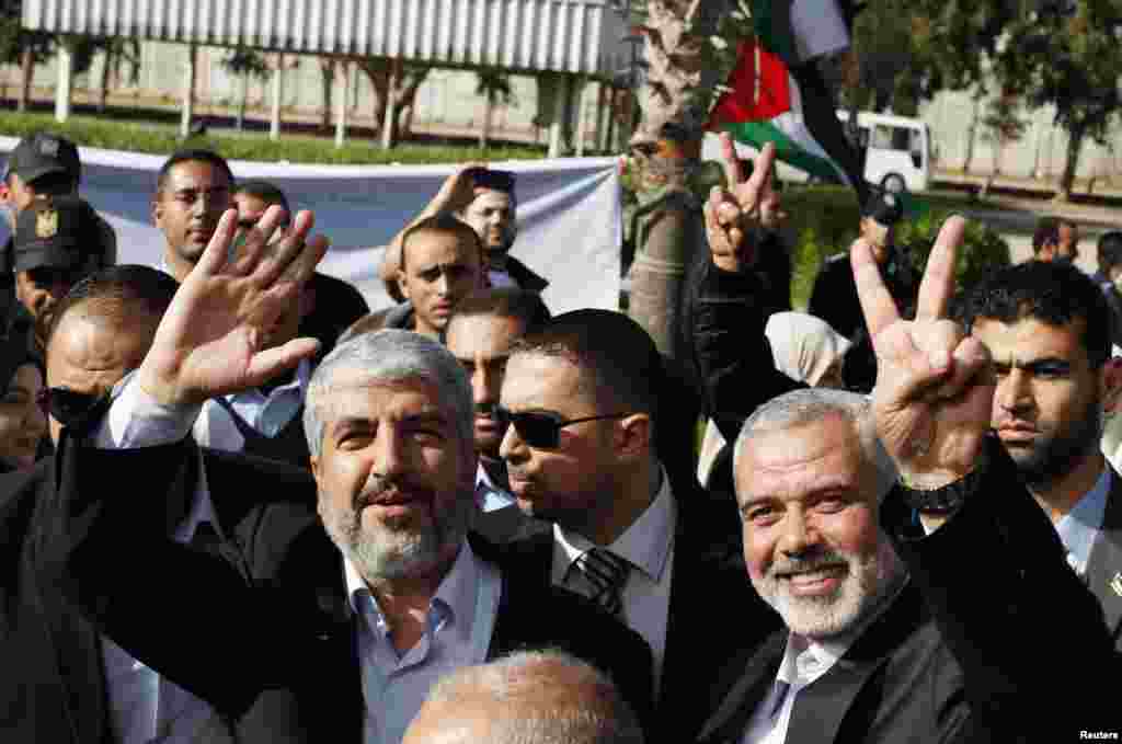 Hamas chief Khaled Meshaal (L) waves as he stands next to senior Hamas leader Ismail Haniyeh upon Meshaal's arrival at Rafah crossing in the southern Gaza Strip December 7. 