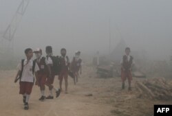 Anak-anak sekolah di Palembang memakai masker akibat pencemaran udara oleh kebakaran hutan di Sumatra (foto: ilustrasi).