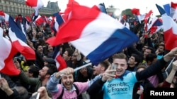 Supporters of French President Elect Emmanuel Macron celebrate near the Louvre museum after early results were announced in the second round vote in the 2017 presidential elections in Paris, France, May 7, 2017. 