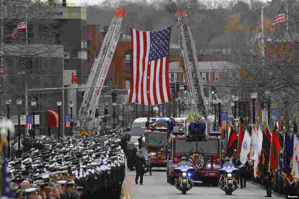 A fire engine carries the body of Boston Fire Department Lieutenant Edward Walsh to his funeral at Saint Patrick&#39;s Church in Watertown, Massachusetts, April 2, 2014. Thousands of firefighters from across the United States lined the streets for the funeral of Walsh, one of two firefighters who died battling a blaze in a Boston apartment building last week.