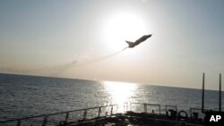 In this photo provided by the U.S. Navy, a Russian Sukhoi Su-24 attack aircraft makes a low altitude pass by the USS Donald Cook in the Baltic Sea, April 12, 2016.