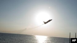 In this photo provided by the U.S. Navy, a Russian Sukhoi Su-24 attack aircraft makes a low altitude pass by the USS Donald Cook in the Baltic Sea, April 12, 2016.