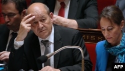 French Defence Minister Jean-Yves Le Drian (L) and French Environment and Energy Minister Segolene Royal attend a session of questions to the government at the National Assembly, on May 07, 2014 in Paris. 