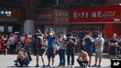FILE - Journalists and residents gather as the Chinese authorities secure the United States Consulate in Chengdu in southwest China's Sichuan province, July 27, 2020.