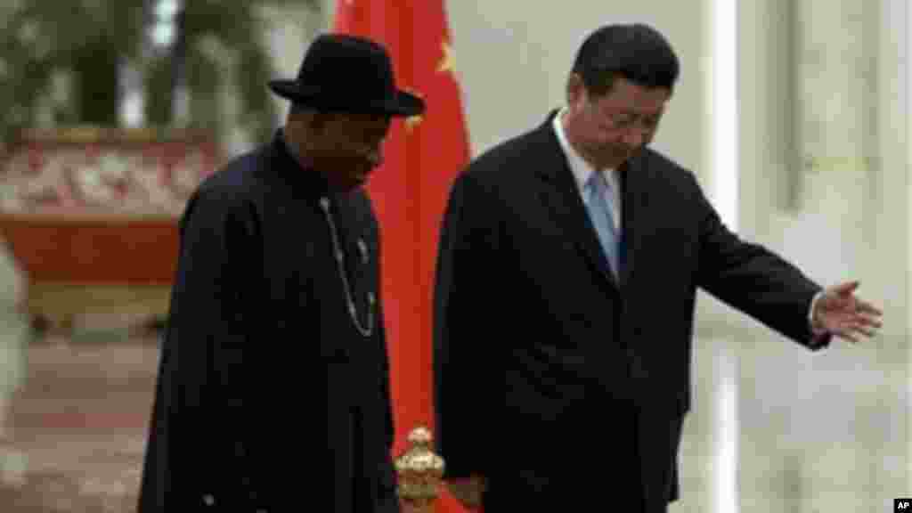 Chinese President Xi Jinping gestures to invite President Jonathan to review an honor guard during a welcome ceremony in Beijing.