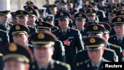 Military delegates from the Chinese People's Liberation Army (PLA) walk towards the Great Hall of the People for a plenary meeting of the National People's Congress (NPC), China's parliament, in Beijing, March 4, 2014.