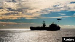 FILE - The Nimitz-class aircraft carrier USS John C. Stennis conducts a replenishment-at-sea with the dry cargo and ammunition ship USNS Charles Drew, Nov. 13, 2018.