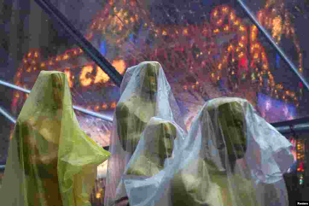 Covered Oscars statues rest under a tent to guard against rain along the red carpet ahead of the 86th Academy Awards in Hollywood, California, March 1, 2014.&nbsp;