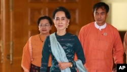 FILE - National League for Democracy party (NLD) leader Aung San Suu Kyi, center, arrives at Myanmar's parliament in Naypyitaw, Myanmar, March 15, 2016. 