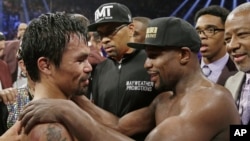 Manny Pacquiao, from the Philippines (L), and Floyd Mayweather Jr., embrace in the ring at the finish of their welterweight title fight in Las Vegas, May 2, 2015.
