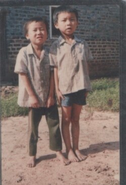 童年的程万里（右）和弟弟在江西老家门口。