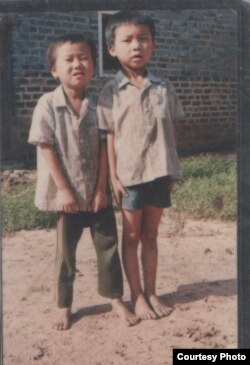 童年的程万里（右）和弟弟在江西老家门口。