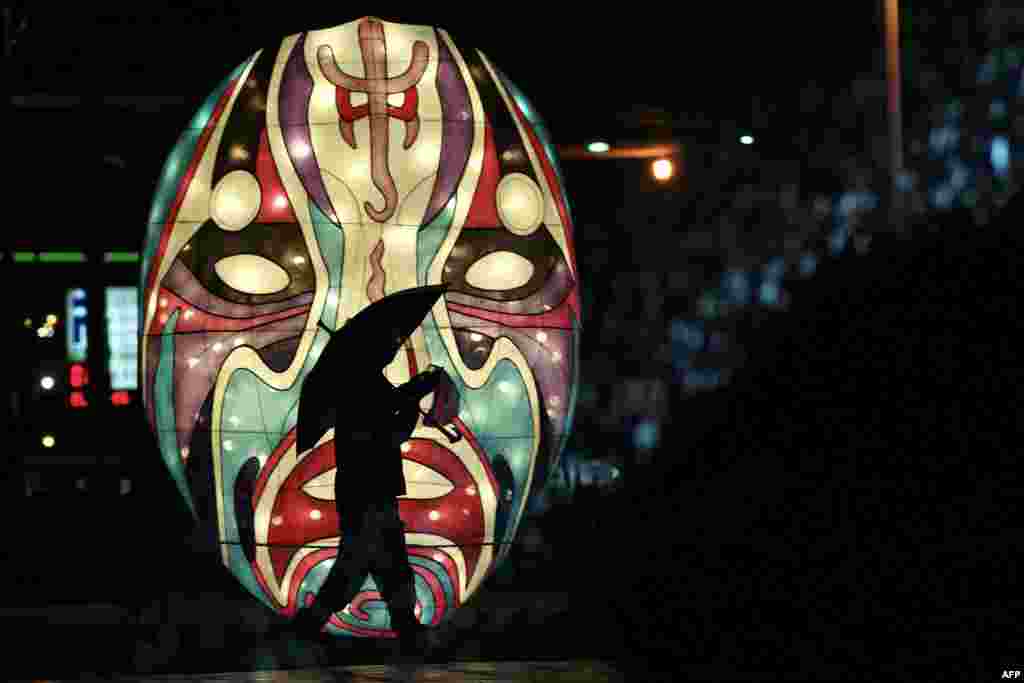 A local walks past a lantern during the fourth day of the Lunar New Year in New Taipei City.