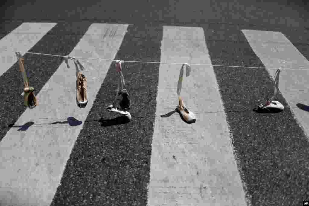 Ballet shoes hang from a rope as part of a protest against the recent decision to reduce funding to the state-run dance company in Buenos Aires, Argentina.