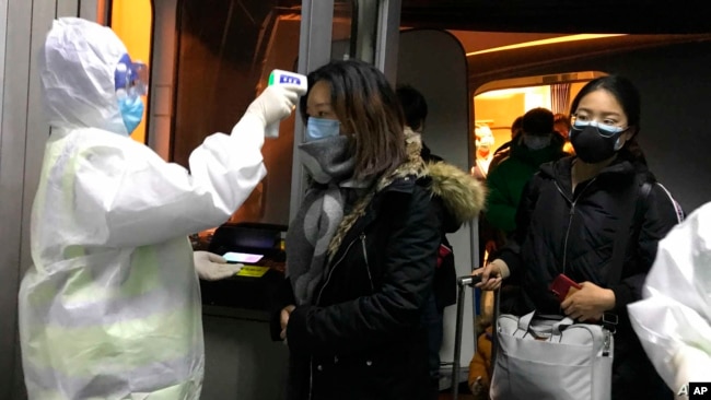 北京检疫人员2020年1月22日在机场测量来自武汉旅客的体温