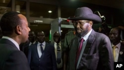 South Sudan's President Salva Kiir, right, is greeted by Ethiopia's Prime Minister Abiy Ahmed, left, as Kiir arrives for a meeting with South Sudan's opposition leader Riek Machar, in Addis Ababa, Ethiopia, June 20, 2018.