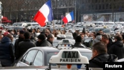 Striking French taxi drivers attend a national protest about competition from private car ride firms like Uber, in Paris, Jan. 26, 2016.