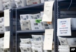 Bins filled with ballots are stacked at the Broward County Supervisor of Elections office as employees count ballots during a recount in Lauderhill, Florida, Nov. 14, 2018.