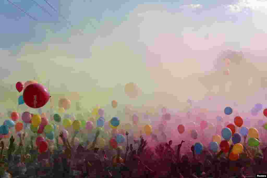 Participants throw colored powders as they take part in the Color Run in the Andalusian capital of Seville, Nov. 2, 2014. The Color Run is a 5K, untimed race held in cities worldwide, with the aim of promoting healthy living.