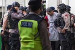 Pemimpin Jemaah Ansharut Daulah (JAD) Zainal Anshori dikawal oleh polisi bersenjata setelah sidang pengadilan di Jakarta pada 31 Juli 2018. (Foto: AFP/Bay Ismoyo)