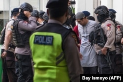 Pemimpin Jemaah Ansharut Daulah (JAD) Zainal Anshori dikawal oleh polisi bersenjata setelah sidang pengadilan di Jakarta pada 31 Juli 2018. (Foto: AFP/Bay Ismoyo)