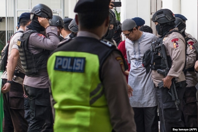 Pemimpin Jemaah Ansharut Daulah (JAD) Zainal Anshori dikawal oleh polisi bersenjata setelah sidang pengadilan di Jakarta pada 31 Juli 2018. (Foto: AFP/Bay Ismoyo)