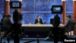 Russian Prime Minister Dmitry Medvedev (C) talks during an interview broadcast on state television in Moscow, Russia, Dec. 9, 2015.