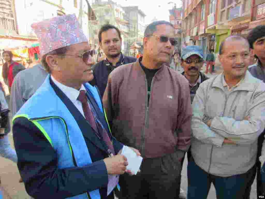 Election observer Tulsi Thappa from the Human Rights Council of Nepal talks to voters in Kathmandu, Nov. 19, 2013. (Aru Pande/VOA) 