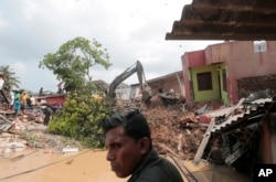 Sri Lankan army soldiers and rescue workers attend to buried houses in a collapse of a garbage dump in Meetotamulla, on the outskirts of Colombo, Sri Lanka, April 15, 2017. A part of the garbage dump that had been used in recent years to dump the waste from capital Colombo collapsed destroying houses, according to local media reports.