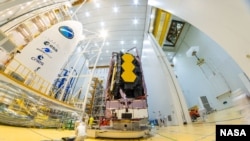 Deze bestandsfoto, genomen op 11 december, laat zien dat NASA's James Webb-ruimtetelescoop is bevestigd bovenop een Ariane 5-raket die hem de ruimte in zal lanceren vanuit de Europese ruimtehaven in Frans-Guyana.  (Bron afbeelding: ESA-M.Pedoussaut)