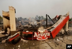 Smoke rises from an Arby's Restaurant that was destroyed by a wildfire in Santa Rosa, Calif., Monday, Oct. 9, 2017.