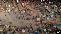 Migrants, many from Haiti, are seen at an encampment along the Del Rio International Bridge near the Rio Grande, Sept. 21, 2021, in Del Rio, Texas. 
