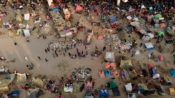 Migrants, many from Haiti, are seen at an encampment along the Del Rio International Bridge near the Rio Grande, Sept. 21, 2021, in Del Rio, Texas. 