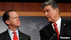 Los senadores Pat Toomey (izquierda) y Joe Manchin informan sobre el acuerdo bipartidista para extender la revisión de antecedentes de los potenciales compradores de armas.