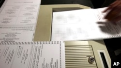 FILE - Paper ballots are fed into a machine during a recount in the 2013 attorney general election in Virginia.