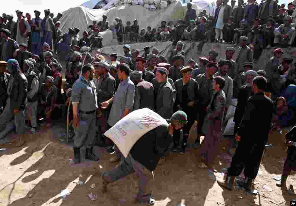 Survivors wait to receive food donations near the site of the landslide that buried Abi-Barik village in Badakhshan province, northeastern Afghanistan, May 6, 2014.