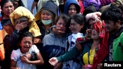 Relatives of missing passengers of a ferry that sank cry while throwing flowers into Lake Toba in Simalungun, North Sumatra, Indonesia July 3, 2018.