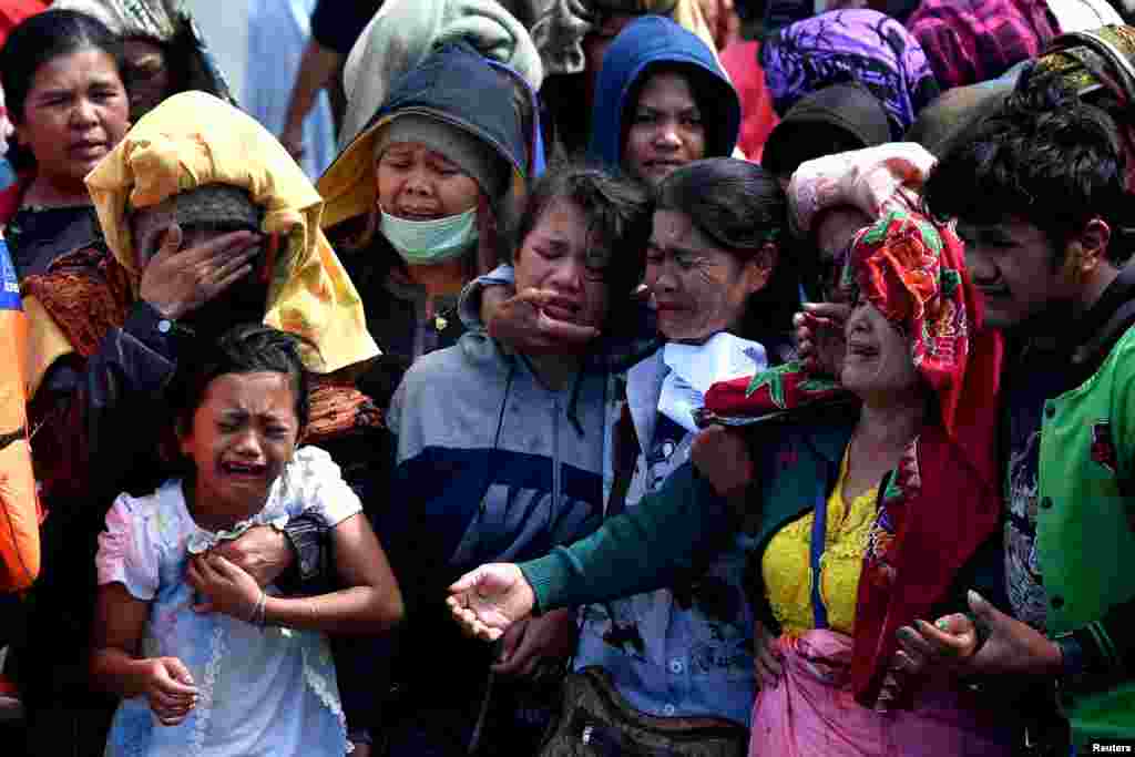 Relatives of missing passengers of a ferry that sank cry while throwing flowers into Lake Toba in Simalungun, North Sumatra, Indonesia. (Credit: Antara Foto)