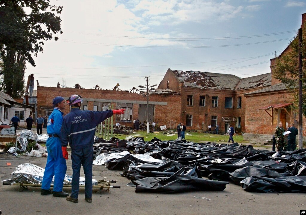 袭击过后，紧急救援人员将遇难者尸体移至学校外空地暂时停放(photo:VOA)