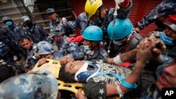 Pemba Tamang is carried on a stretcher after being rescued by Nepalese policemen and U.S. rescue workers from a building that collapsed five days ago in Kathmandu, Nepal, Thursday, April 30, 2015. 