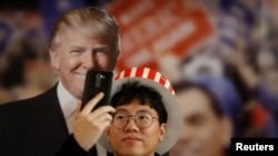 미국에서 대통령 선거를 실시한 지난달 8일, 서울 주미한국대사관에서 한 남성이 트럼프 당시 공화당 후보의 사진을 배경으로 셀피 사진을 찍고 있다.