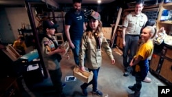 In a Thursday, March 1, 2018 photo, Tatum Weir, center, carries a tool box she built as her twin brother Ian, left, follows after a cub scout meeting in Madbury, N.H. (AP Photo/Charles Krupa)